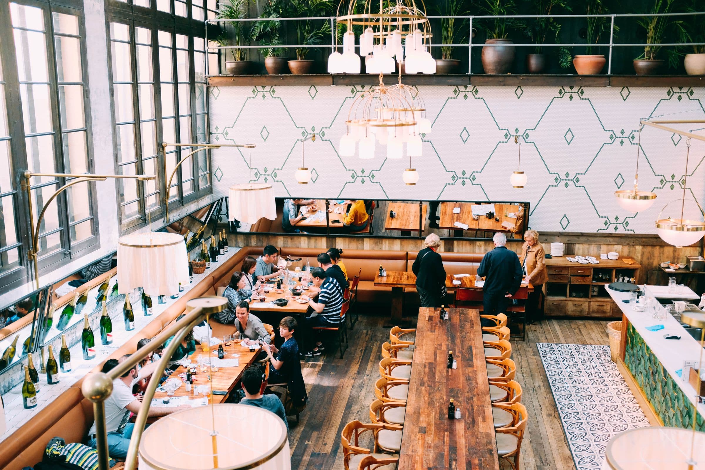Warm modern restaurant with guests dining beneath hanging lights